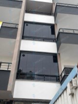 Siyah korkuluklu balkonlarda koyu gri camla kapatma