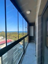 Deniz manzaralı yeni binada uzun balkona siyah profilli cam balkon montajı