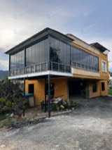 Müstakil evin üst katında çatılı terası çevreleyen cam balkon