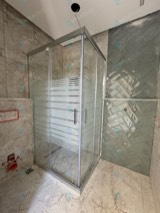 Gümüş profilli şerit camlı köşe duşakabin, yeşil seramik duvar