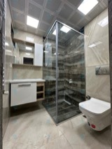 Gümüş profilli şeffaf camlı köşe duşakabin, asma klozetli banyo